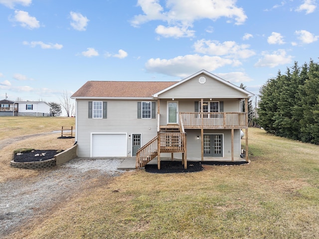 back of house featuring a wooden deck, a garage, and a yard