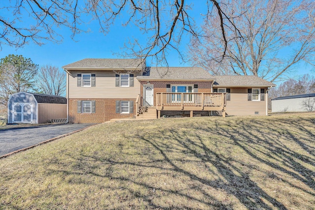 rear view of house featuring a wooden deck, a yard, and a storage shed