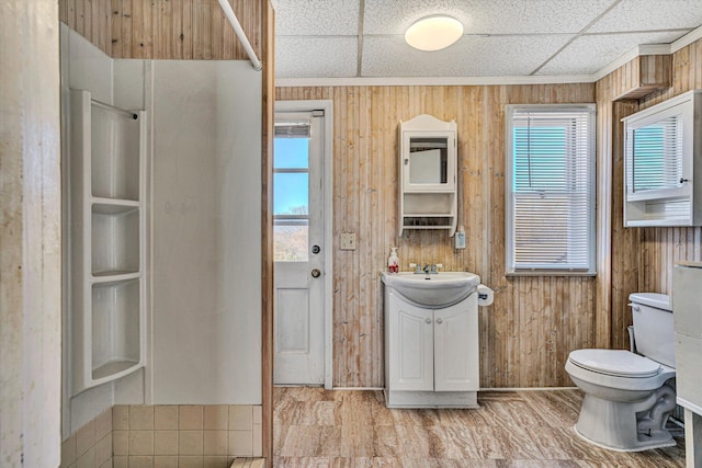 bathroom featuring vanity, a drop ceiling, and wood walls