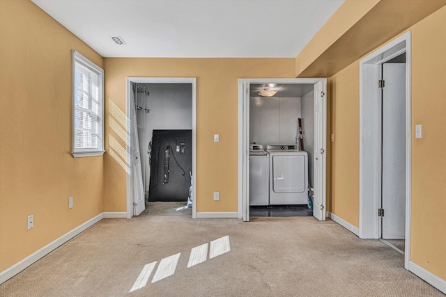 clothes washing area featuring washing machine and clothes dryer and light colored carpet