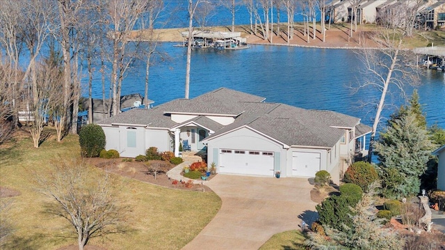 view of front facade featuring a garage, a water view, and a front lawn