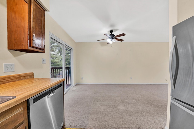 kitchen with stainless steel appliances, light carpet, and ceiling fan