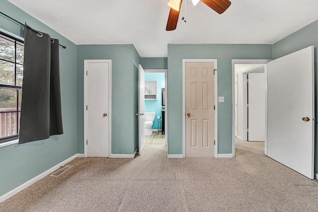 unfurnished bedroom with connected bathroom, light colored carpet, and ceiling fan