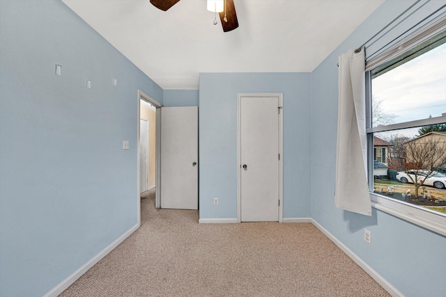 unfurnished bedroom with ceiling fan and light carpet