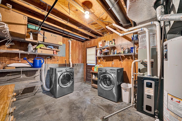 clothes washing area featuring gas water heater and washer and clothes dryer