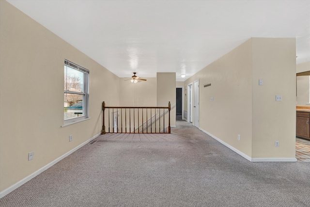 carpeted spare room featuring ceiling fan