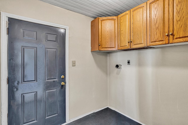 clothes washing area featuring baseboards, hookup for an electric dryer, and cabinet space