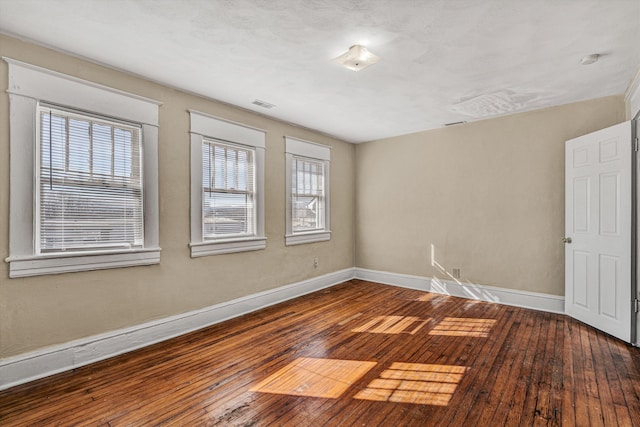 empty room with hardwood / wood-style flooring and baseboards