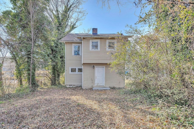 back of house with a chimney