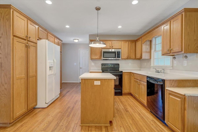 kitchen with a kitchen island, sink, hanging light fixtures, light hardwood / wood-style floors, and black appliances