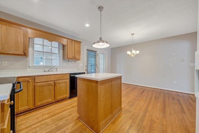 kitchen featuring hanging light fixtures, black appliances, a center island, and light wood-type flooring