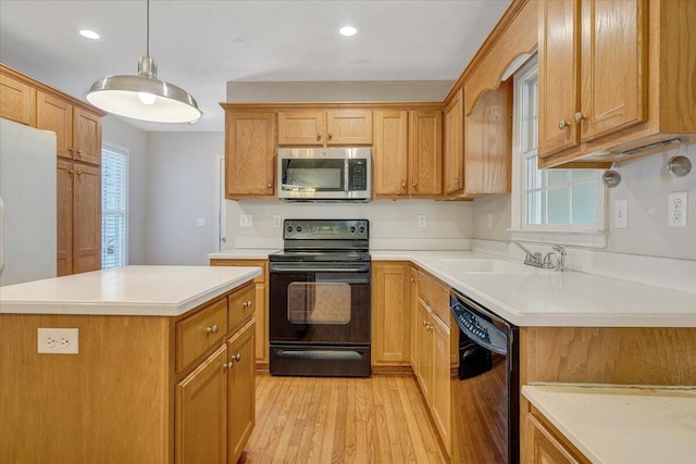 kitchen featuring sink, light hardwood / wood-style flooring, hanging light fixtures, a center island, and black appliances