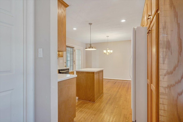 kitchen with a center island, dishwasher, white fridge, pendant lighting, and light hardwood / wood-style floors