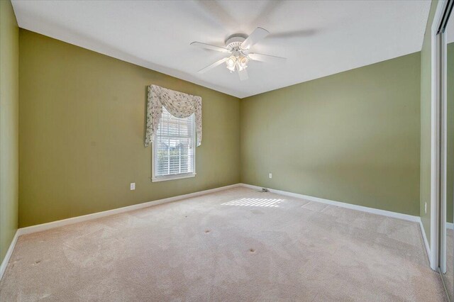 carpeted spare room with ceiling fan