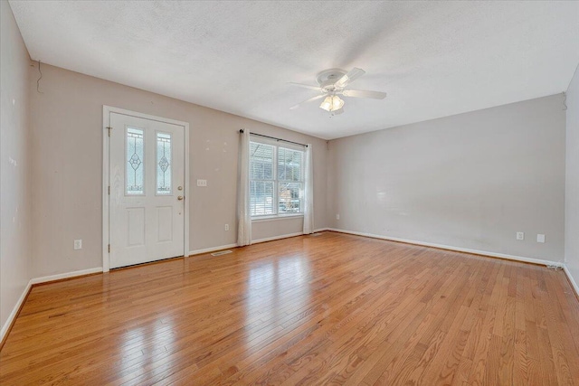 entryway featuring ceiling fan, light hardwood / wood-style flooring, and a textured ceiling