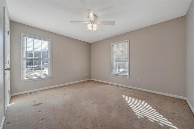 carpeted spare room with ceiling fan