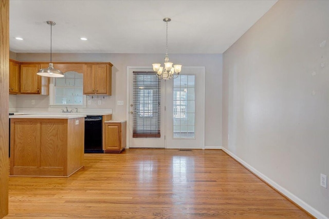 kitchen featuring pendant lighting, dishwasher, light hardwood / wood-style flooring, and a notable chandelier