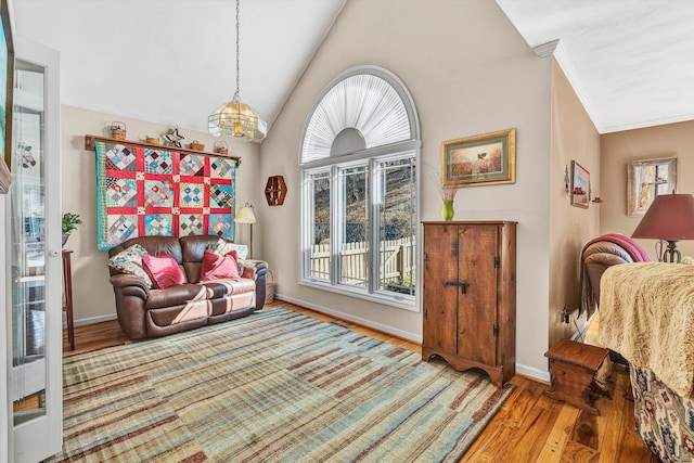 living area featuring hardwood / wood-style flooring, lofted ceiling, and crown molding