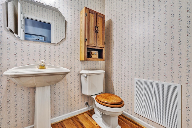 bathroom with hardwood / wood-style floors and toilet