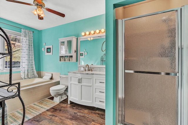 full bathroom featuring toilet, vanity, ceiling fan, plus walk in shower, and hardwood / wood-style floors