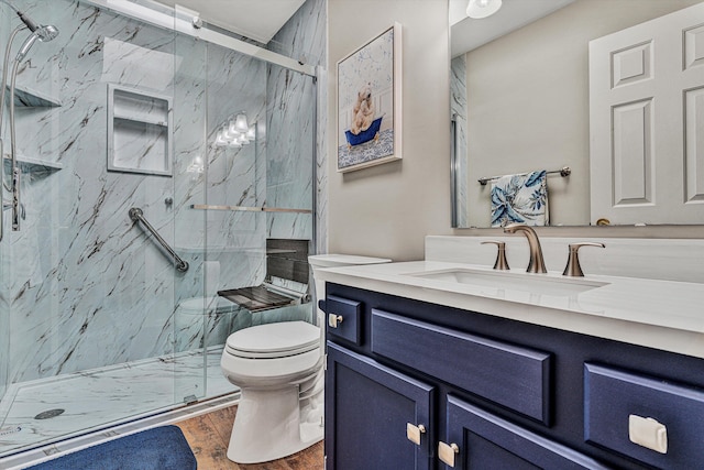 bathroom featuring hardwood / wood-style flooring, vanity, toilet, and a shower with door