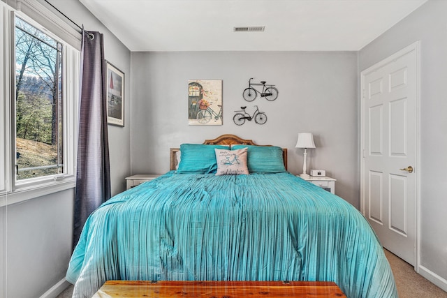 carpeted bedroom featuring multiple windows