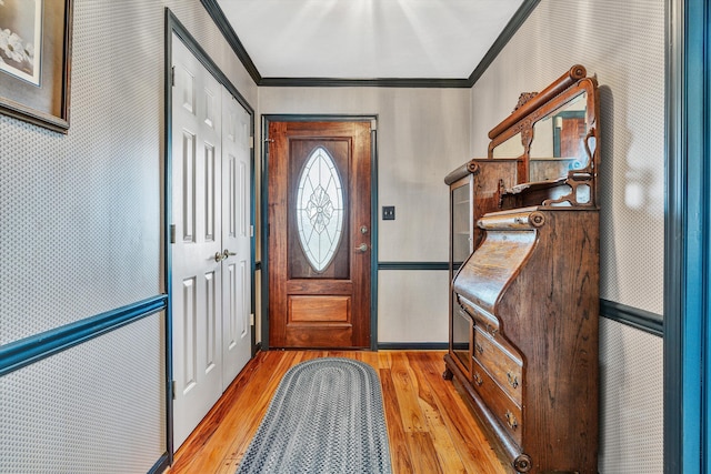 foyer entrance featuring ornamental molding and light hardwood / wood-style floors