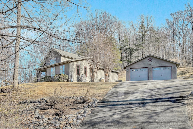 view of front of home with a garage and an outbuilding