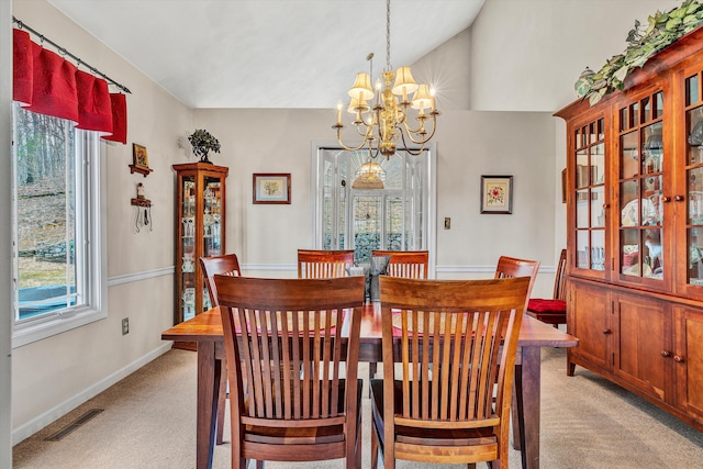 dining room featuring light colored carpet, lofted ceiling, and a notable chandelier