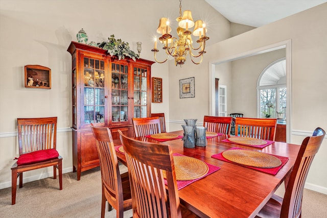 carpeted dining area featuring lofted ceiling and an inviting chandelier