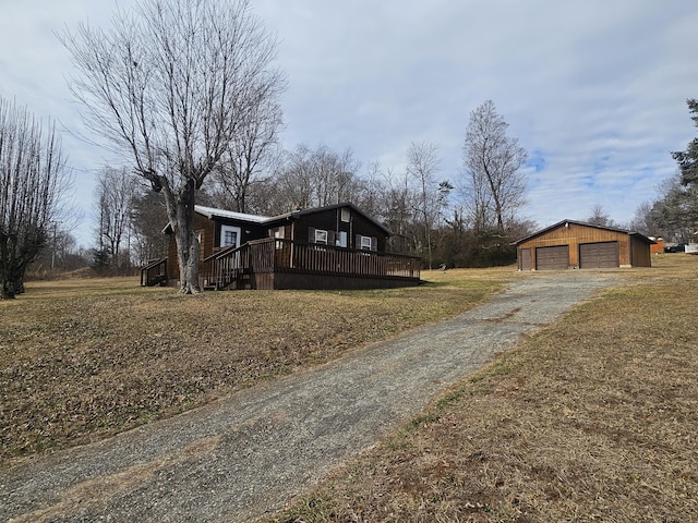 view of front of home with a garage, an outdoor structure, and a front yard