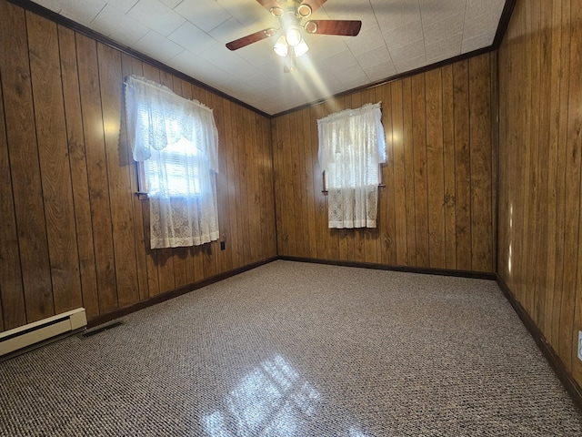 empty room with crown molding, wooden walls, a baseboard radiator, and ceiling fan