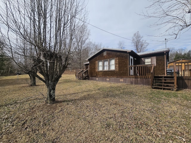 view of side of property featuring a wooden deck and a yard