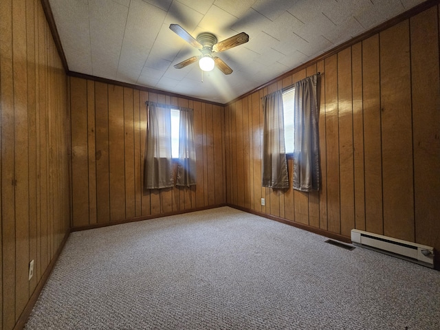 carpeted empty room featuring a baseboard radiator, wooden walls, and ceiling fan