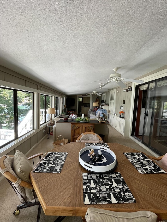 dining room with ceiling fan, lofted ceiling, carpet, and a textured ceiling