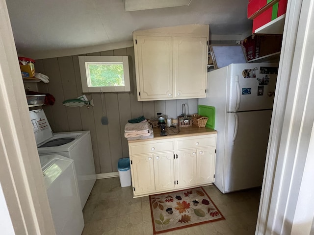 laundry room featuring washing machine and clothes dryer and wood walls