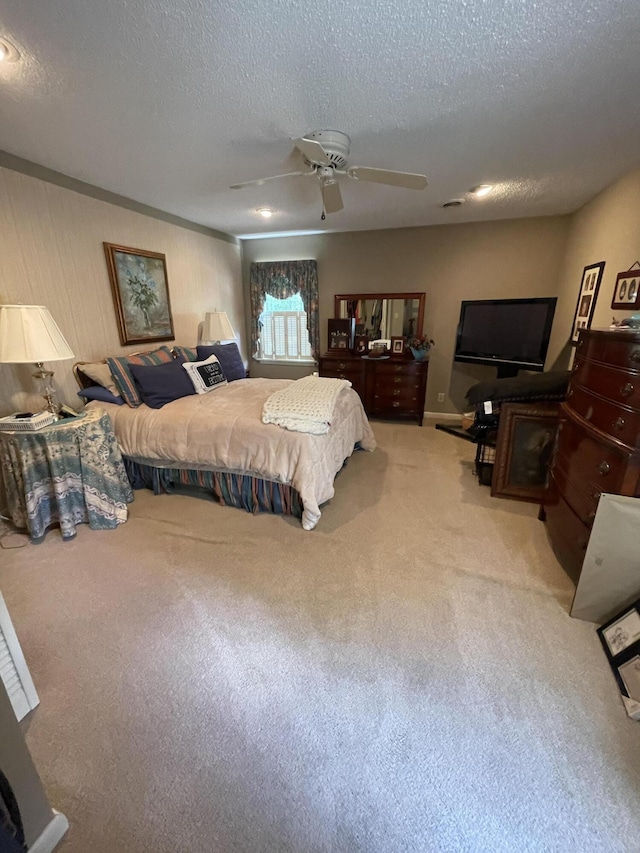 bedroom featuring ceiling fan, carpet floors, and a textured ceiling