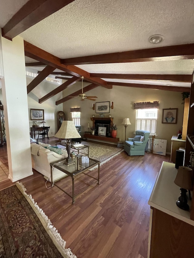 living room with hardwood / wood-style floors, lofted ceiling with beams, a textured ceiling, and ceiling fan