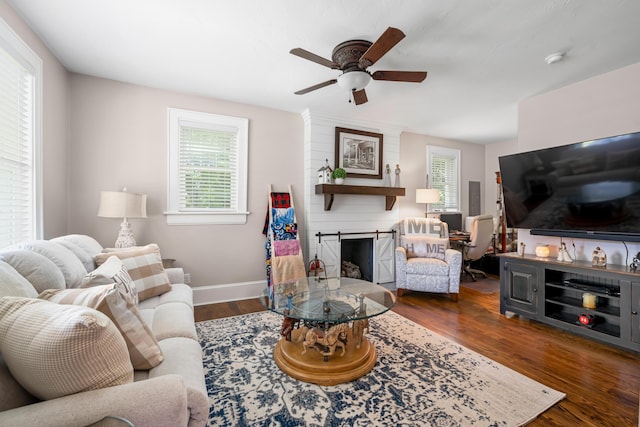 living room with dark hardwood / wood-style flooring, ceiling fan, and a fireplace