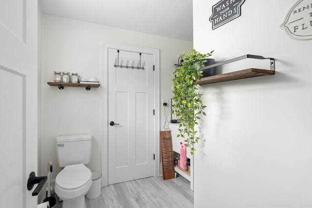 bathroom featuring hardwood / wood-style flooring and toilet