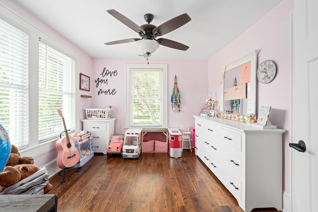 playroom featuring ceiling fan, a healthy amount of sunlight, and dark hardwood / wood-style floors