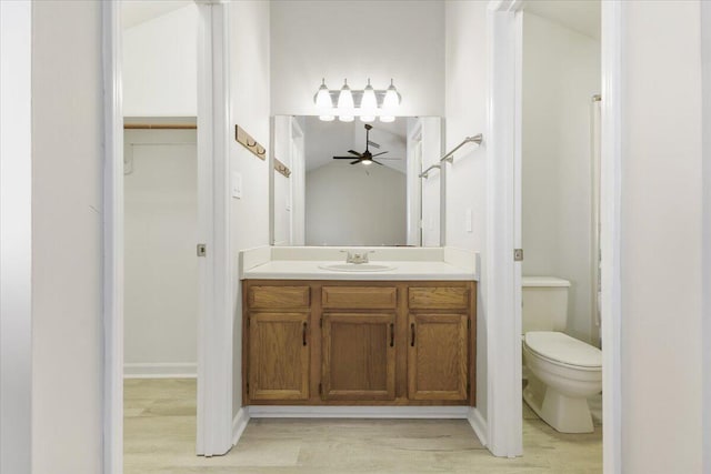 bathroom with vanity, wood-type flooring, lofted ceiling, and toilet