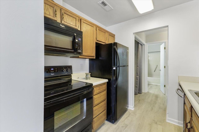 kitchen featuring light hardwood / wood-style flooring and black appliances