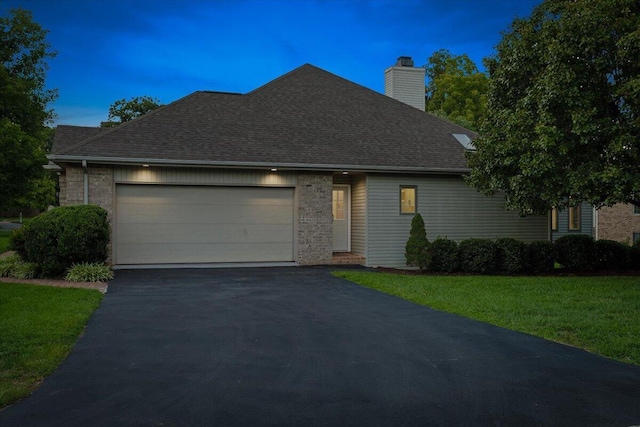 view of front of home featuring a garage and a yard