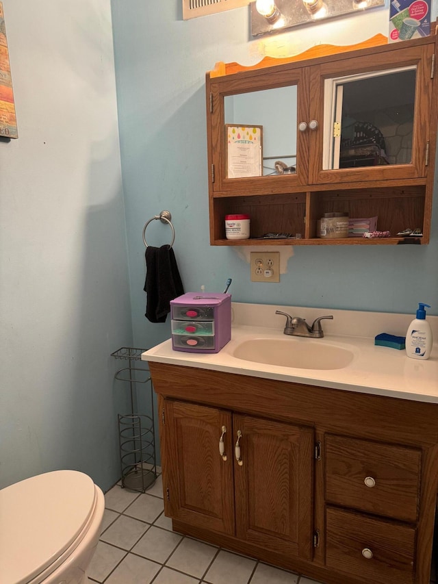 bathroom with tile patterned flooring, vanity, and toilet