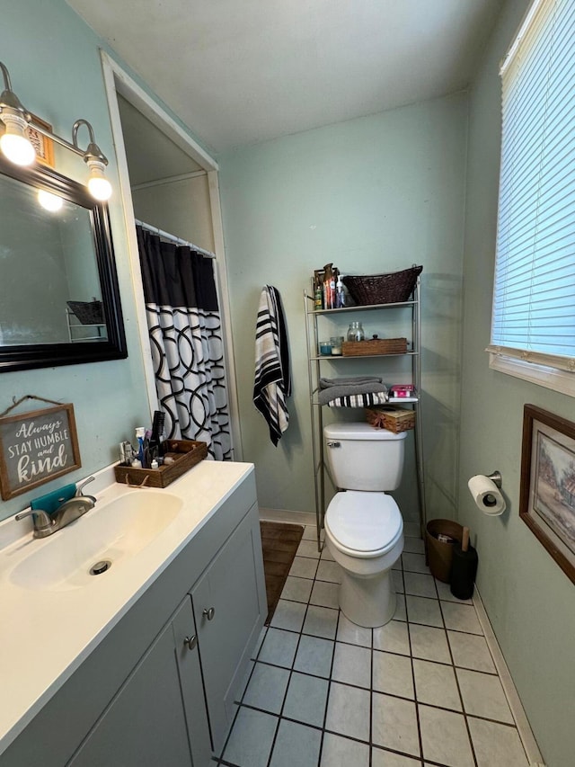 bathroom with a shower with curtain, vanity, tile patterned floors, and toilet