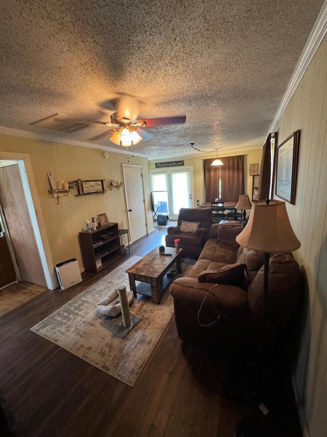 living room featuring ceiling fan, crown molding, wood-type flooring, and a textured ceiling