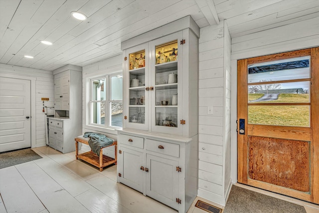 entryway featuring wood ceiling and wood walls