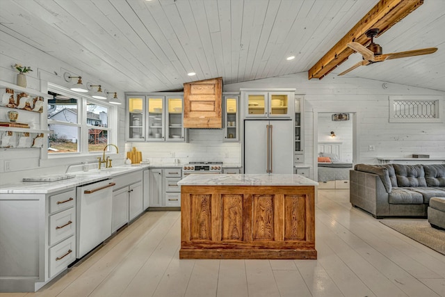 kitchen with a kitchen island, lofted ceiling with beams, white cabinets, white dishwasher, and high end fridge