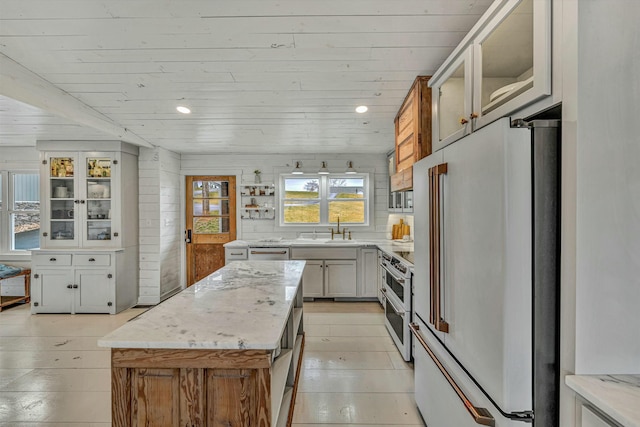 kitchen with a kitchen island, sink, wooden ceiling, and premium appliances